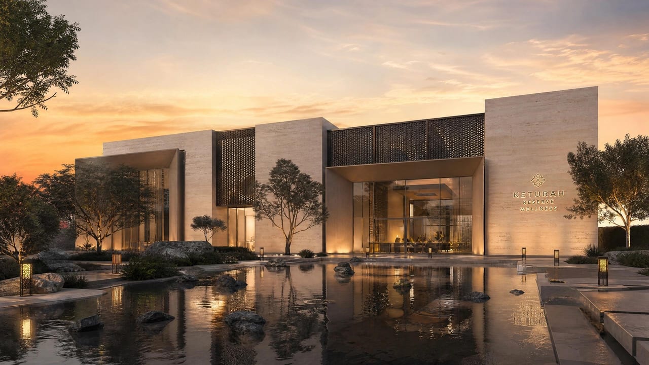 The wellness centre — long horizontal stone volumes screened by mature trees.